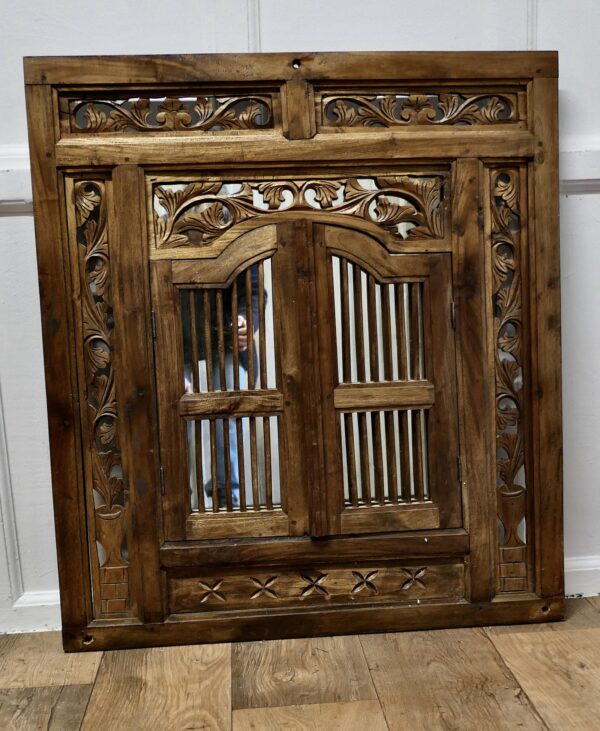 Wall Mirror Concealed by Heavy Carved Teak Door Shutters